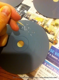 Gray acrylic paint on the back of a CD. Scraping away paint with toothpick.