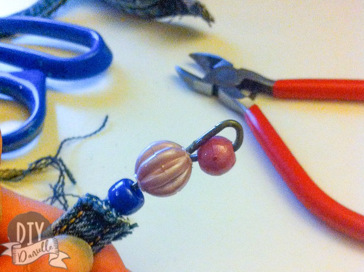 Beads on the end of a DIY denim bracelet.