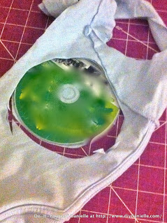Using an old CD to cut out fabric for nursing pads. I upcycled some old tshirts for the absorbency inside the pads.