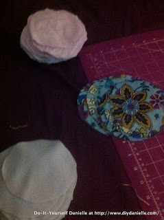 Cutting fabric to make nursing pads.
