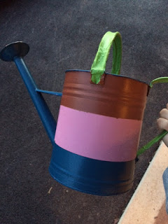 Using painters tape to paint a watering can red, white, and blue.