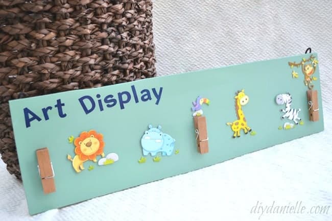 How to make an art display from leftover flooring. Cute zoo animal art display with clips to hold artwork or homework.