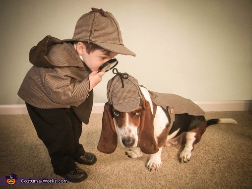 The dog's face is priceless, and they make a dynamic duo in the Holmes and Watson costumes!