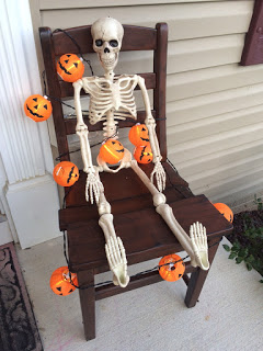 Skeleton seated in our chair for Halloween decor.