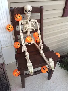 Skeleton seated in our chair for Halloween decor.