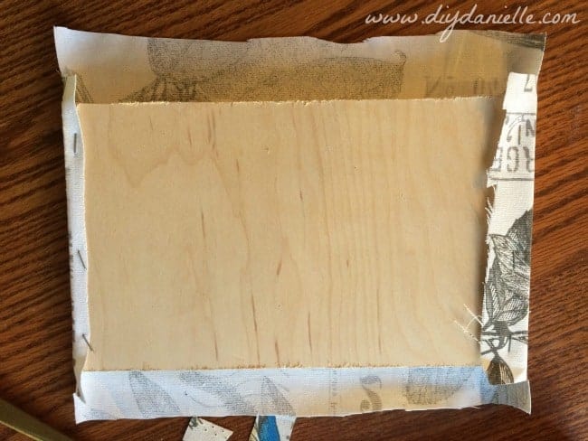 Use a staple gun to staple  the fabric to the wood.