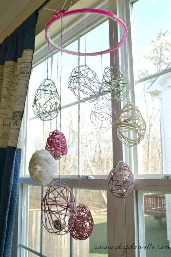 Our Easter Egg Wind Chime DIY, hanging from a curtain rod.