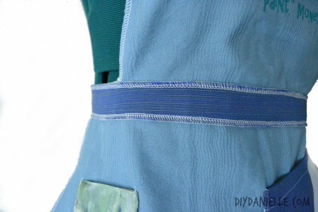 Waist strap sewn onto apron.
