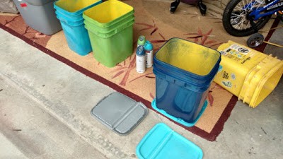 Upcycled Kitty Litter Buckets being Spray Painted.