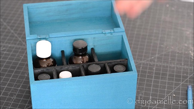 Paint the inner dividers of the essential oil storage box.