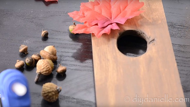 Add Fall embellishments like fake fall leaves and acorns. Use a glue gun or other sturdy glue.