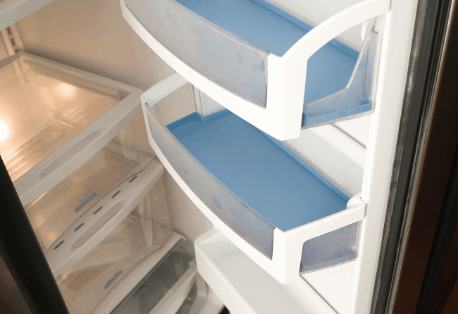 Photo of a clean refrigerator. Get some quick and easy hacks for cleaning the refrigerator.