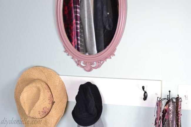Mirror and coat rack in a master bedroom closet.