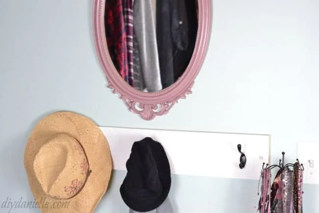 Mirror and coat rack in a master bedroom closet.
