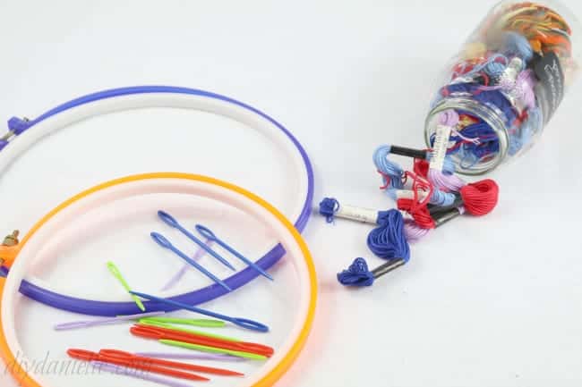 Supplies include plastic needles for children, plastic embroidery hoops and embroidery thread.