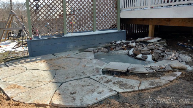 Stone laid for the patio around the pond.