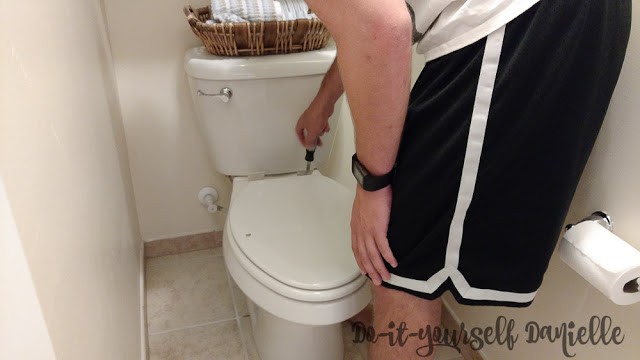 Removing the toilet seat to install a bidet seat.