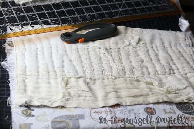 Cutting flannel to cover the frayed prefold diaper.