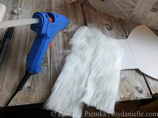 Adding fur to the cardboard cutout for the angel's wings.