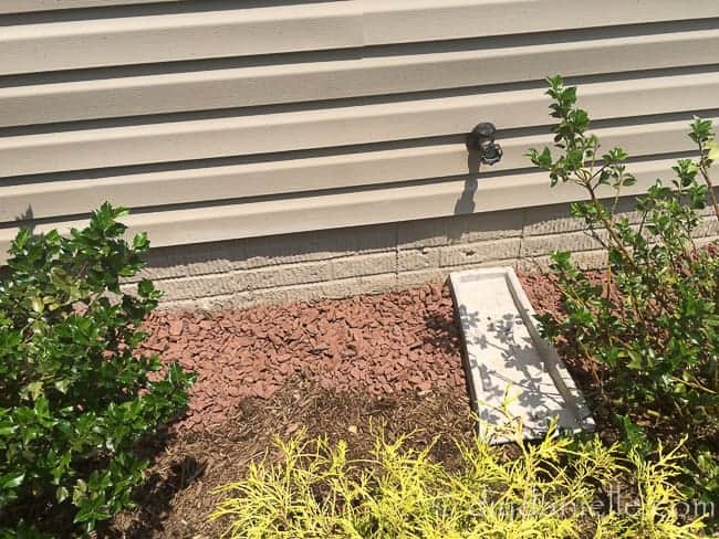 Barrier along the side of the house with rock and pond liner.