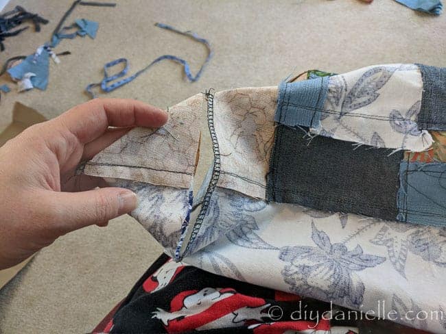 Creating a boxy bottom to the bag by cutting a triangle off each bottom side of the bag.