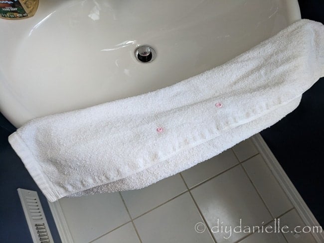 Snaps applied to the inside of a hand towel to help keep the towel from falling off.
