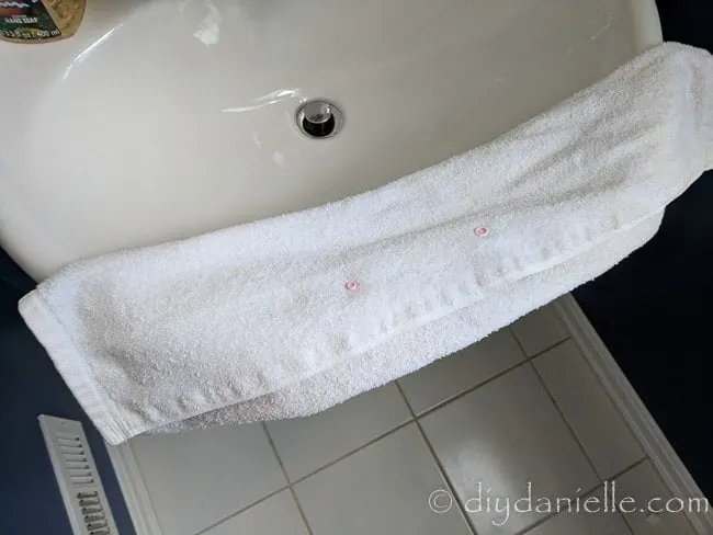 Snaps applied to the inside of a hand towel to help keep the towel from falling off.
