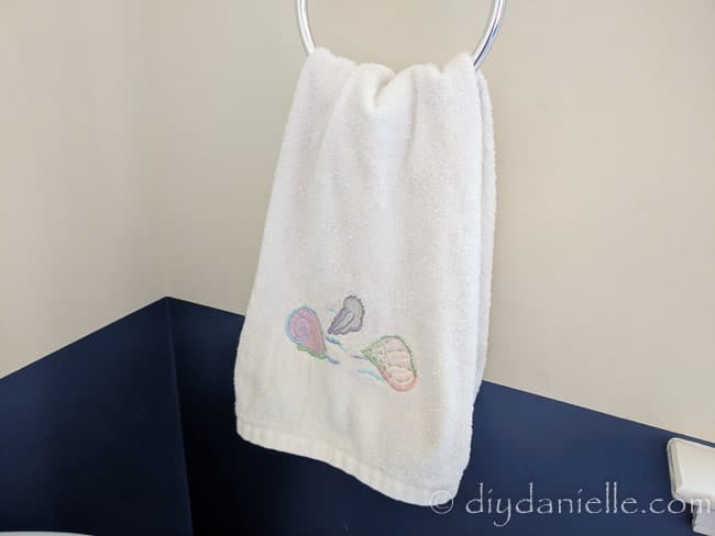 How to keep your hand towels from ending up on the floor. Sea shell towel hanging on a towel ring. 