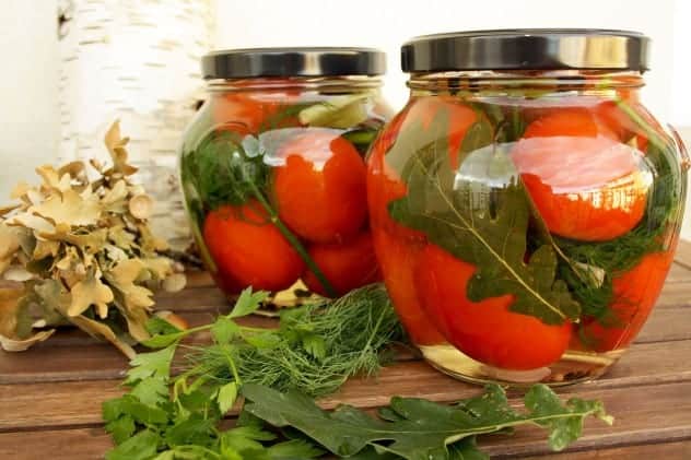 Pretty pickled tomatoes in jars.