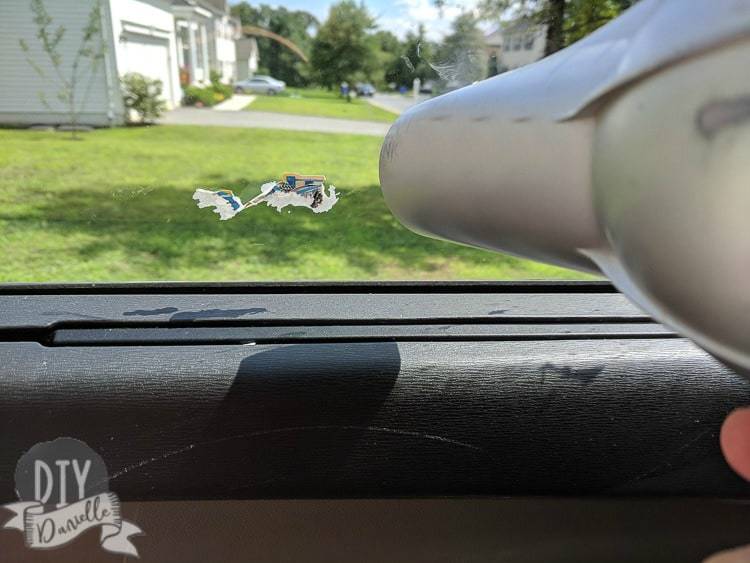 Removing stickers from a window using a hair dryer.