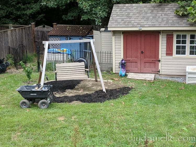 Covering dead grass from a pool with mulch.