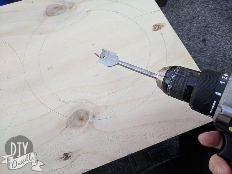 Using a spade bit to make a hole in the feeder.