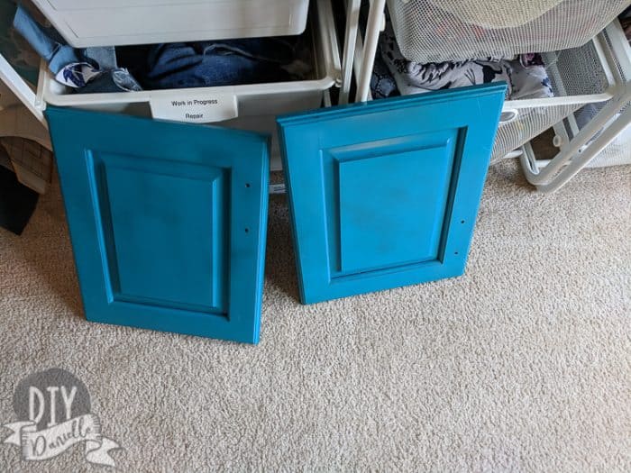 Upcycling a cabinet door. Painted blue before adding vinyl.