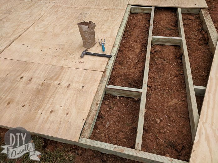 Setting up supports for the shed base before hammering in the plywood.