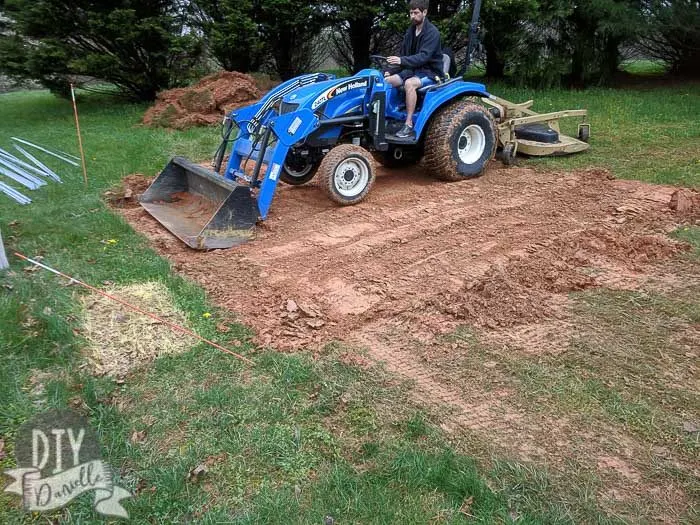 Using a tractor to level the ground before placing a base for a 10x12 shed.