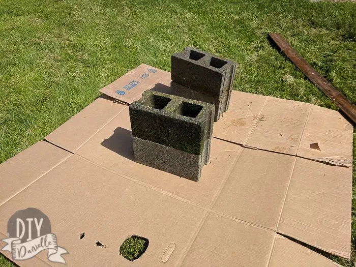 Four old cinder blocks being prepped to use for a DIY bench.