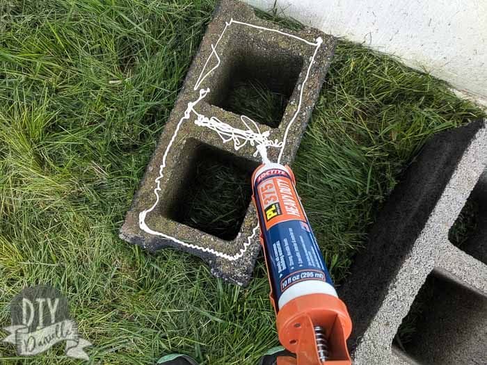 Adding adhesive to the cinder blocks.