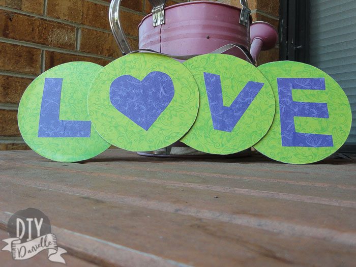 "LOVE" banner made from CDs and scrapbook paper.