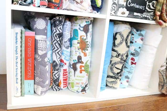 Books for beginner sewers (sewists). Photo: books and fabric on a shelf.