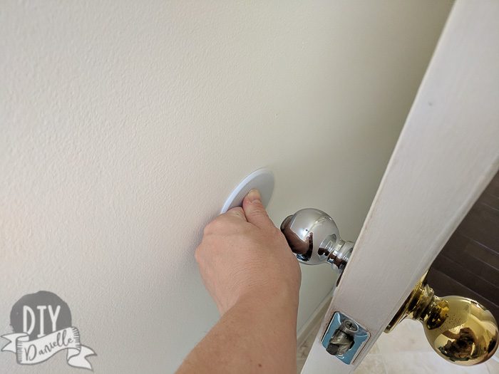 Holding the disc on the wall so it will stick well.