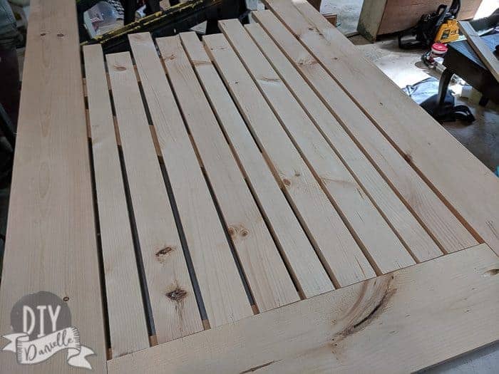 Lining up the vertical pieces of the bottom half of the wood screen door. Note that I drew a little line and put a number for each so I could place them back in the right spot and order.