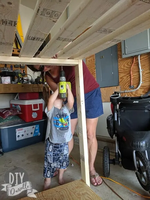 2 year old helping me screw in 2x4s to form the top for the cabana. 