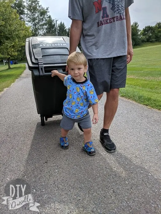 My son in his new Pikachu shirt, helping bring the garbage can home to the house.