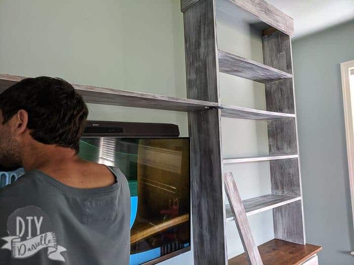 Middle shelf being added to the bookshelves. Two shelves will go over the TV. They're held in place with clamps while my husband screws them in via pocket holes.