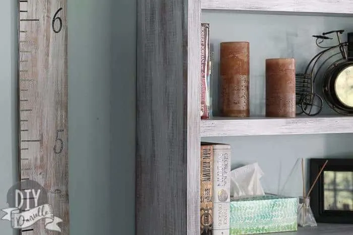 Closeup of our living room bookshelves next to our matching height ruler for the kids.