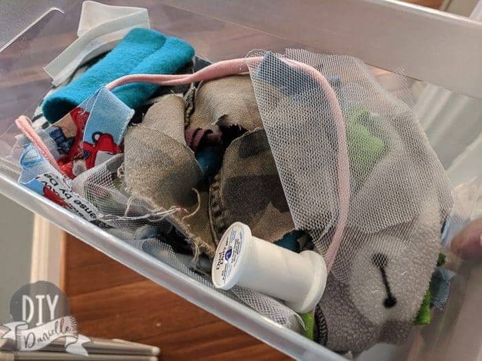Shoebox bin filled with different fabric scraps.