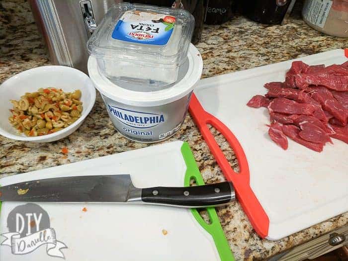 Cutting up meat, cheese and olives for a meal from Plate joy.