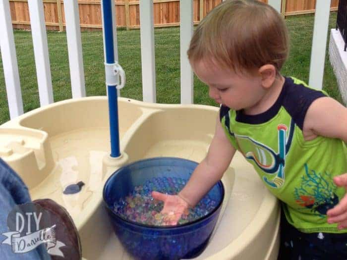 Toddler playing with water beads.