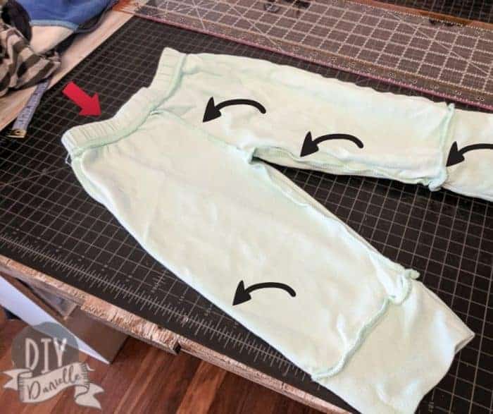 Picture of a pair of baby pants with arrows pointing to different areas that were sewn together.