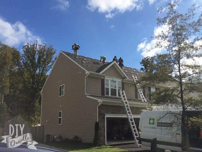 Installers on the roof of the home installing the panels.